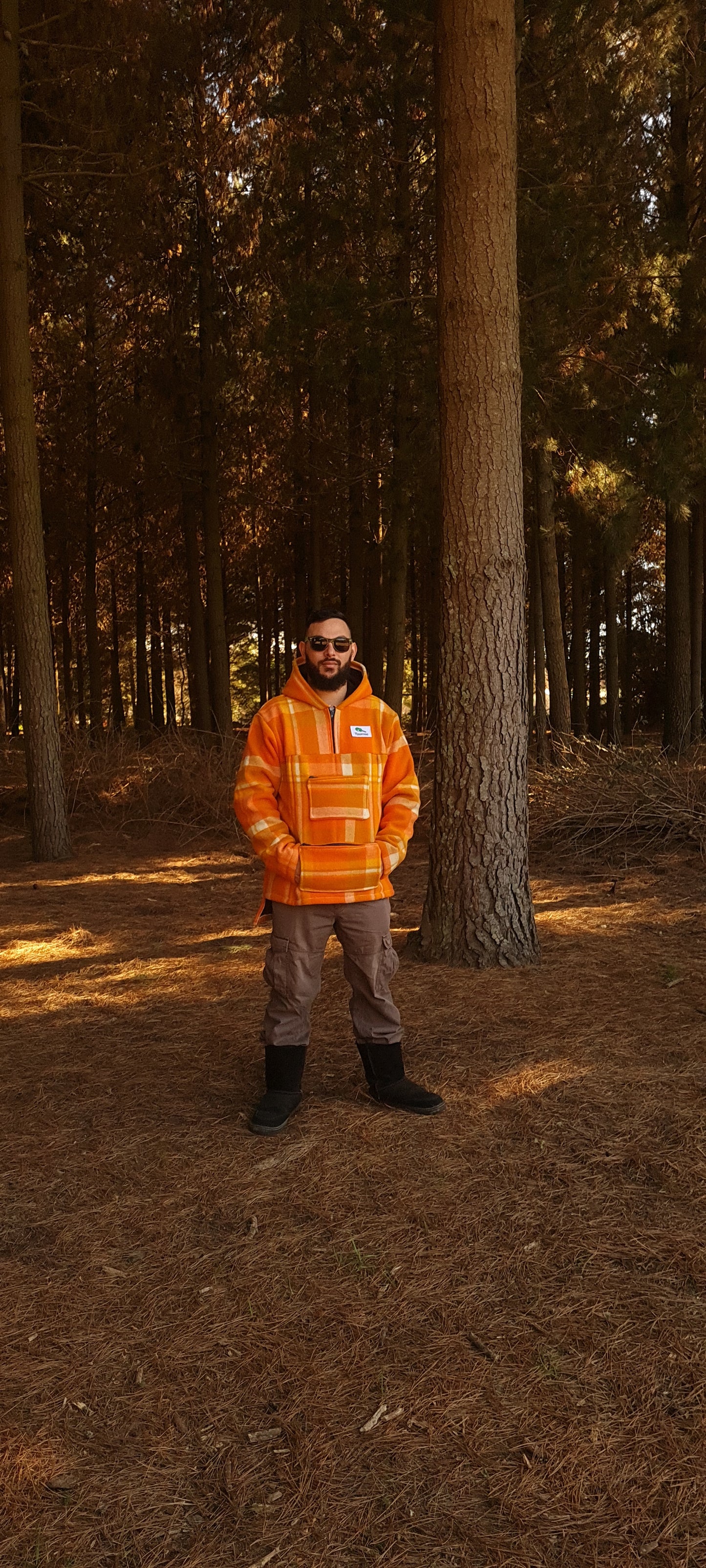   Conquer the wilderness in style with the checked orange Raumoa Wool Anorak Jacket, a versatile hunting jacket crafted for both fashion and functionality. front picture.