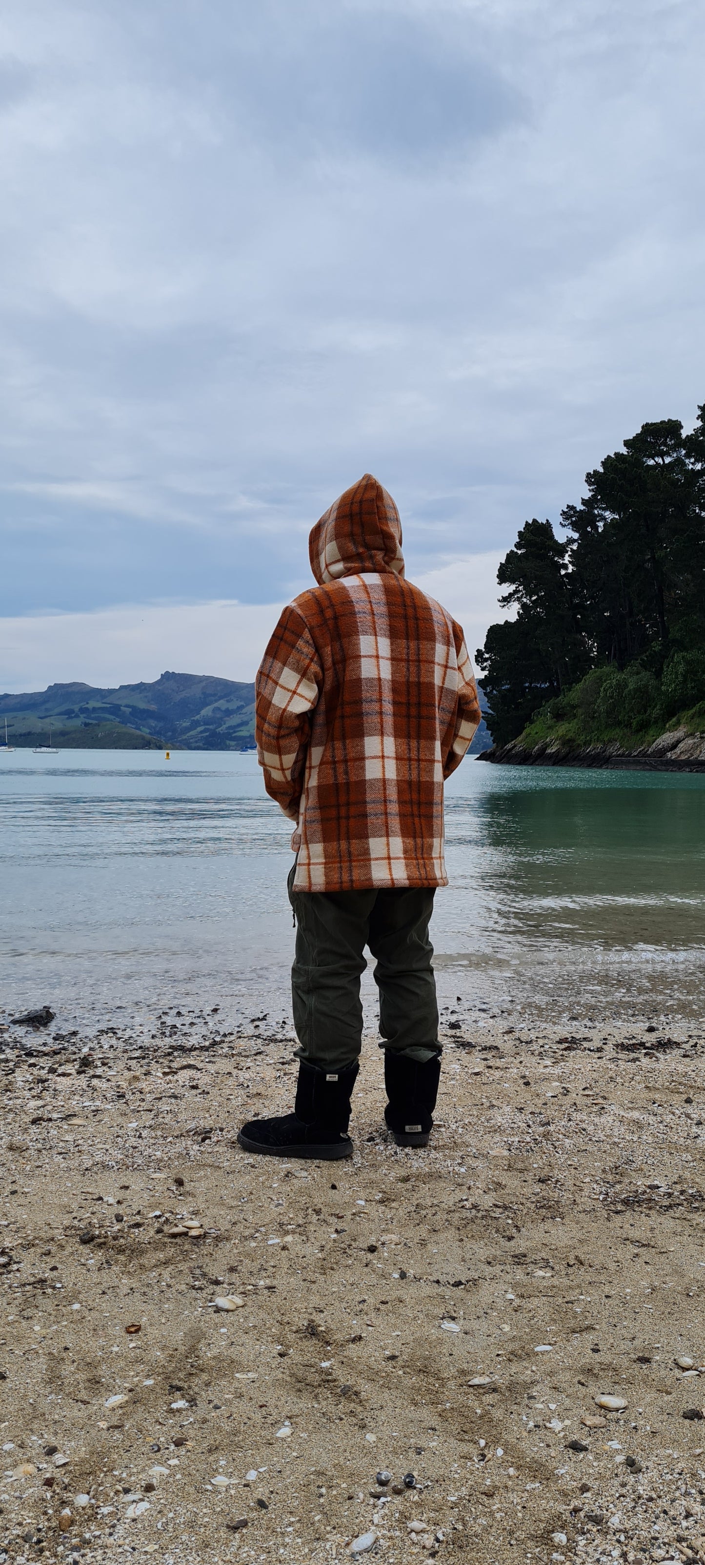 winter wardrobe with the Checked Brown Raumoa Wool Anorak Jacket, a luxurious wool coat inspired by Maori clothing, blending cultural pride with modern fashion. back picture