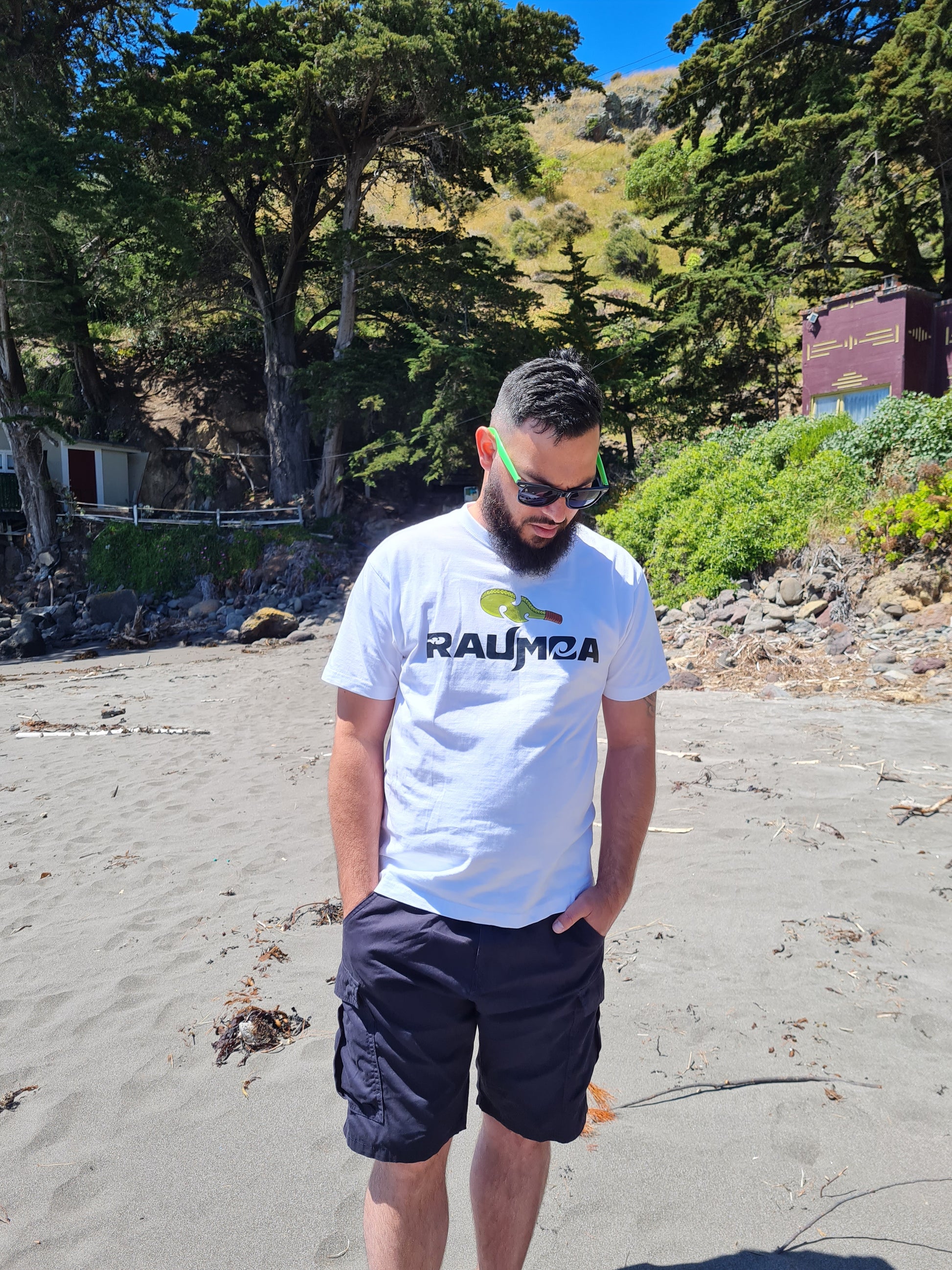 Maori white T-shirt featuring traditional Maori design in vibrant colors. Perfect for adding a touch of New Zealand culture to your wardrobe. Available in various sizes. [Image: Front View of the white t shirt.]