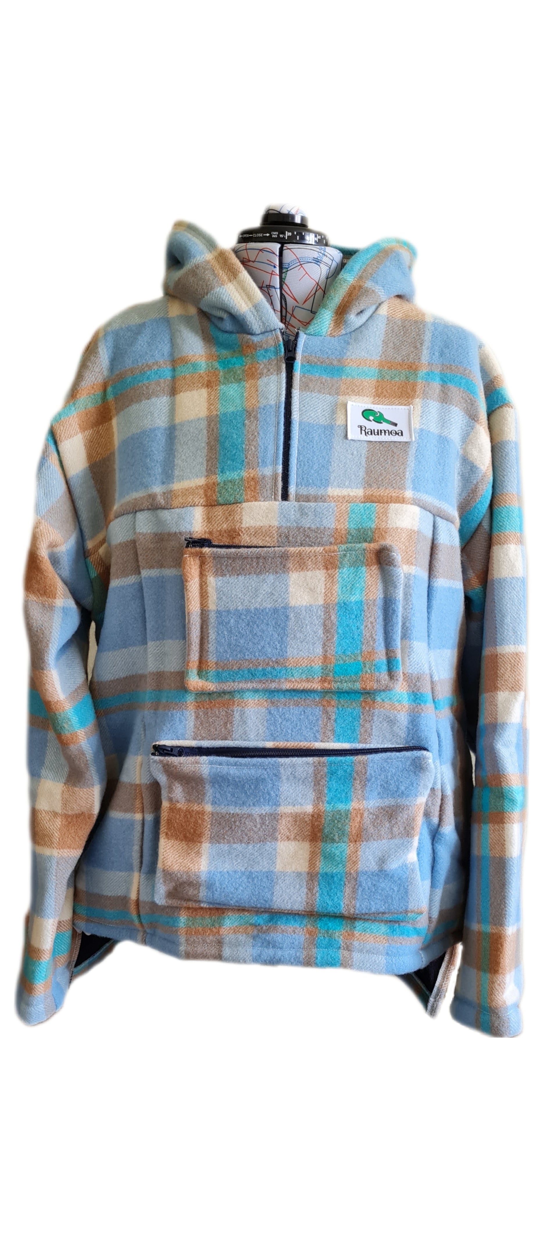 Embark on your next adventure with the Checked Light Blue/Brown Raumoa Wool Anorak Jacket, a versatile hiking jacket that combines style and functionality.