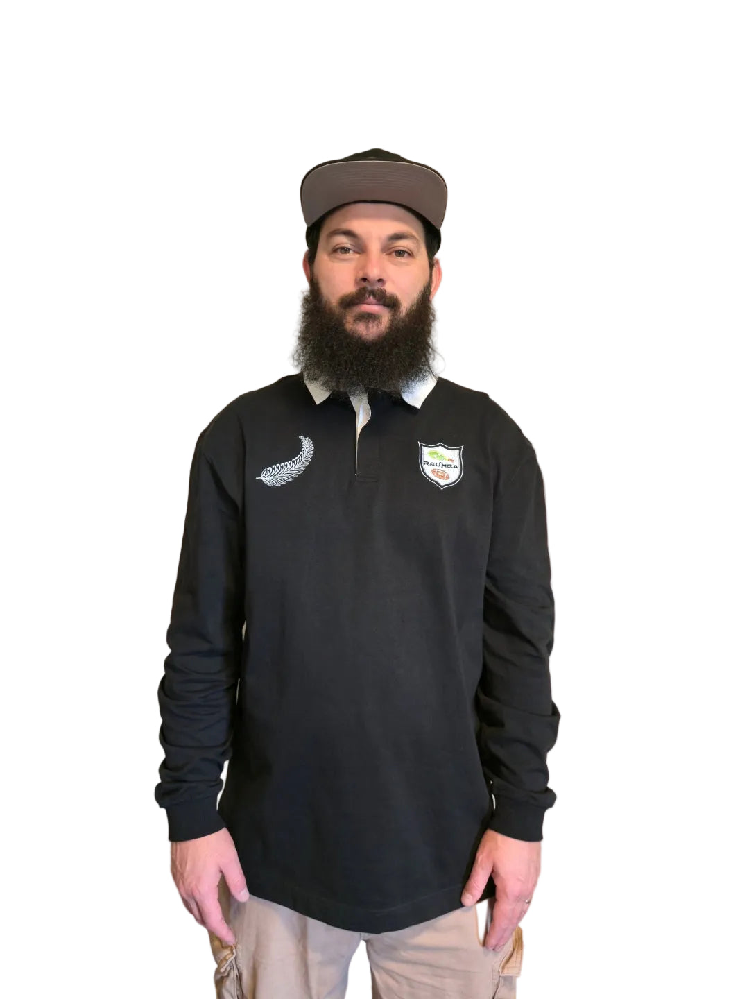 A man wearing a black long-sleeve rugby shirt with a logo and a shield crest on the chest, 